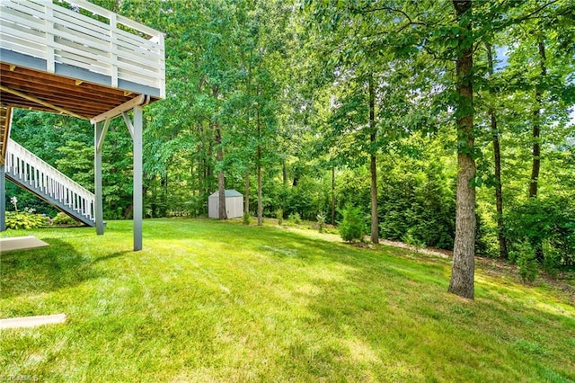 view of yard featuring a storage shed, stairway, and an outbuilding