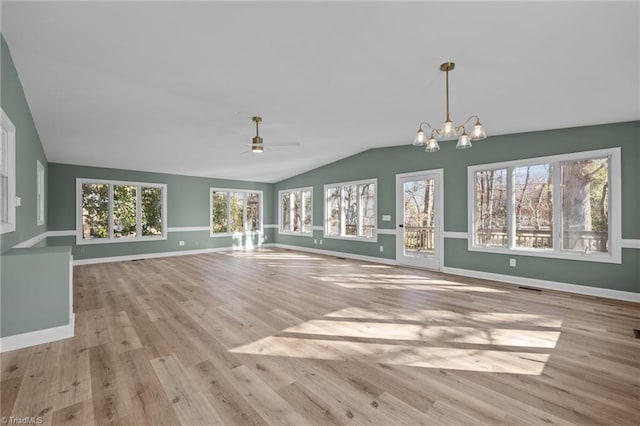 unfurnished living room featuring wood finished floors, visible vents, baseboards, vaulted ceiling, and ceiling fan with notable chandelier