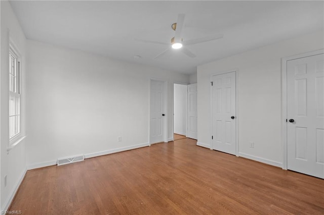 unfurnished bedroom featuring ceiling fan, visible vents, baseboards, and light wood-style flooring