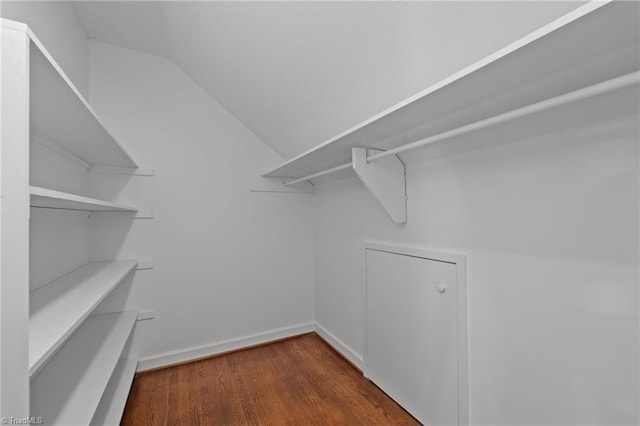 spacious closet with dark wood-type flooring and lofted ceiling