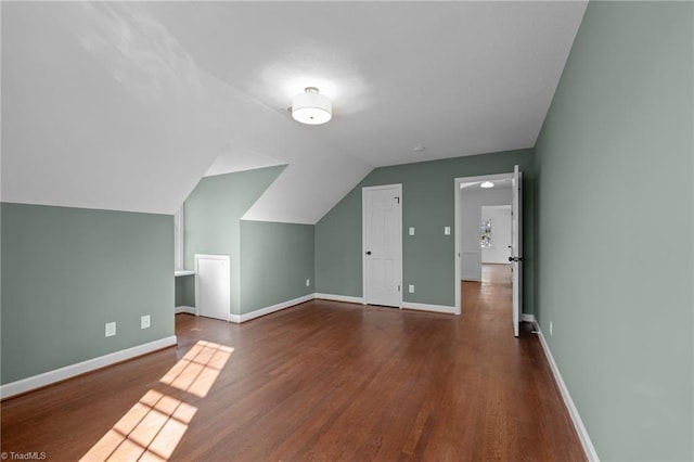 additional living space with vaulted ceiling, wood finished floors, and baseboards