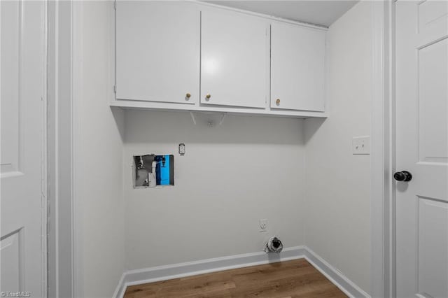 washroom with hookup for a washing machine, baseboards, cabinet space, and dark wood finished floors