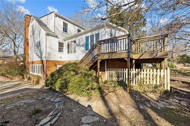 exterior space featuring a wooden deck, stairs, and fence