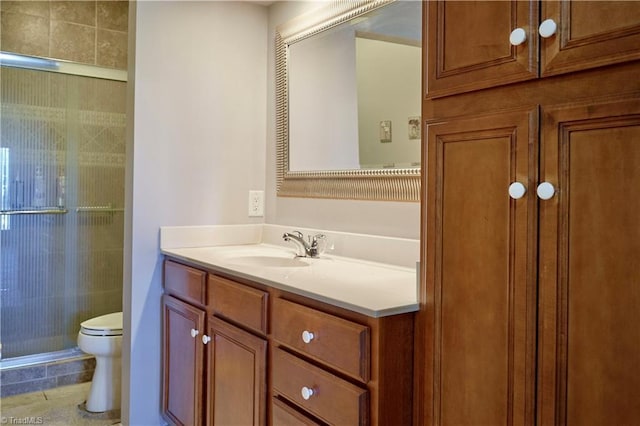 bathroom with a shower with shower door, vanity, and toilet