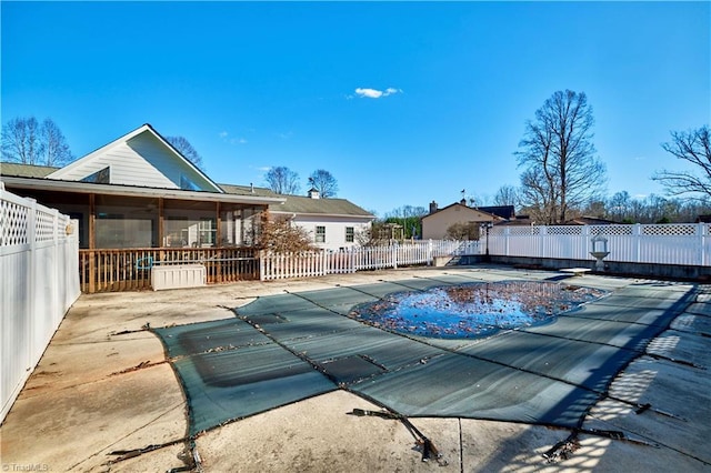 view of swimming pool with a patio area and a sunroom