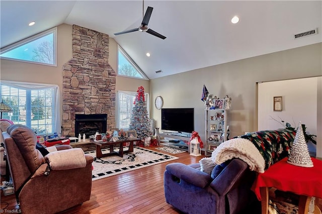 living room with a fireplace, high vaulted ceiling, ceiling fan, and wood-type flooring