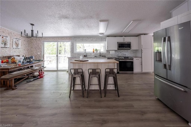 179 Abington Ln, Troutman, NC 28166 - kitchen with appliances with stainless steel finishes, a textured ceiling, white cabinetry, light countertops, and dark wood-style floors