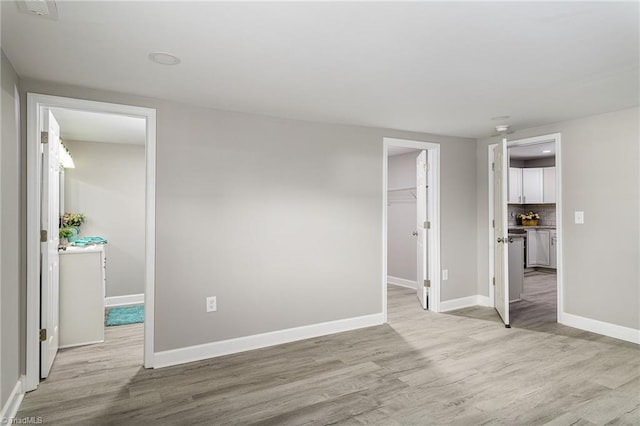 5515 Bethania Rd, Pfafftown, NC 27040 - unfurnished bedroom with light wood-type flooring, a spacious closet, and baseboards