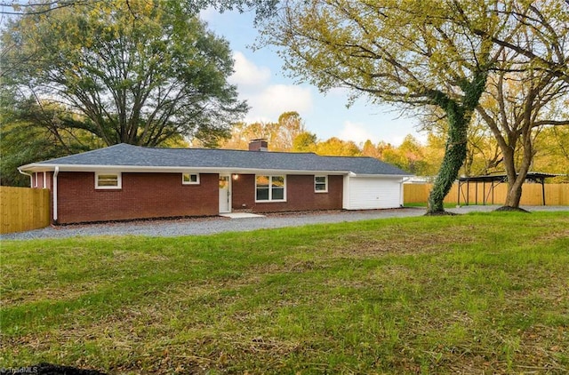 back of house with a patio and a lawn