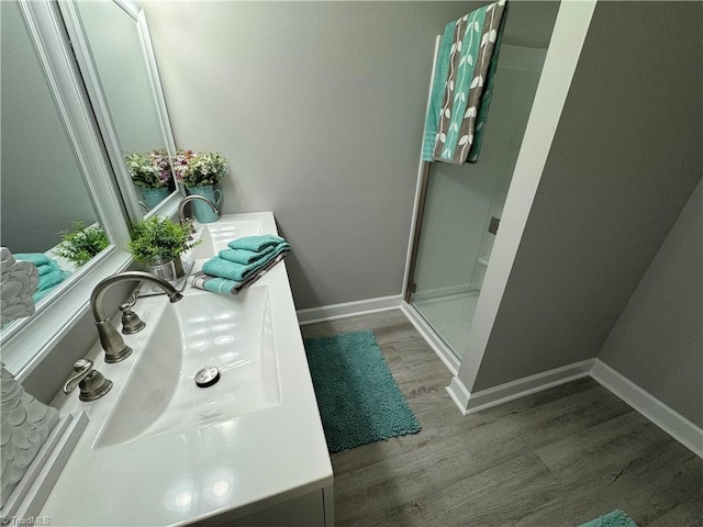 bathroom with vanity, a shower with shower door, and wood-type flooring