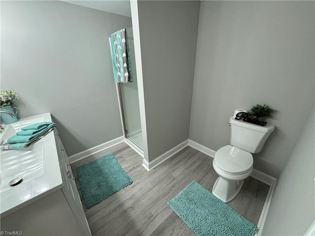 bathroom featuring vanity, toilet, hardwood / wood-style flooring, and walk in shower