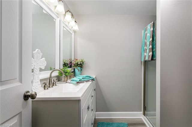 bathroom featuring vanity, hardwood / wood-style floors, and a shower with shower door