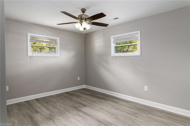 spare room with ceiling fan, a healthy amount of sunlight, and wood-type flooring