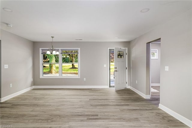 entrance foyer with a notable chandelier and light hardwood / wood-style flooring