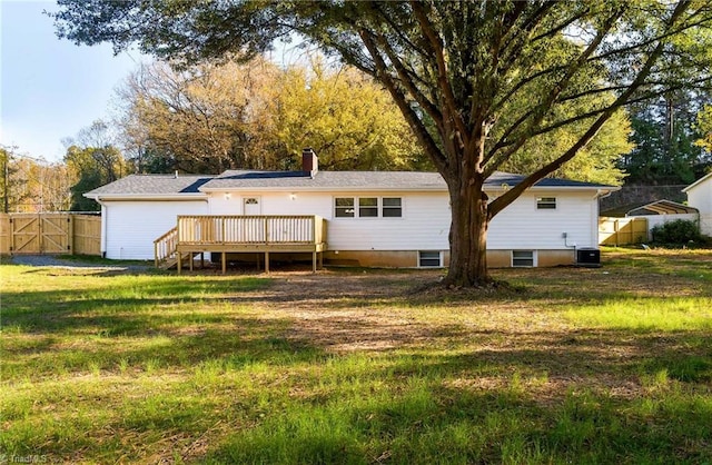 rear view of house with central air condition unit, a deck, and a yard