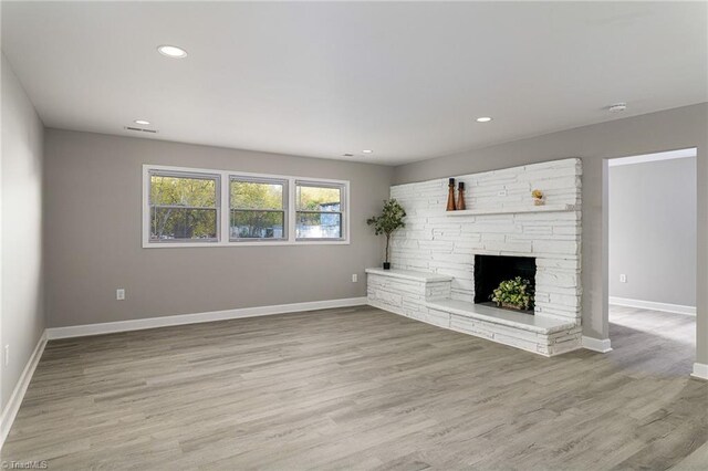 5515 Bethania Rd, Pfafftown, NC 27040 - unfurnished living room with baseboards, light wood-type flooring, recessed lighting, and a stone fireplace