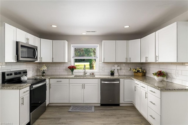 5515 Bethania Rd, Pfafftown, NC 27040 - kitchen featuring stainless steel appliances, a sink, decorative backsplash, white cabinets, and recessed lighting
