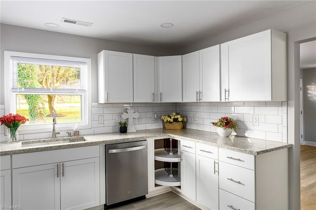 5515 Bethania Rd, Pfafftown, NC 27040 - kitchen with stainless steel dishwasher, a sink, backsplash, light wood-style floors, and white cabinetry