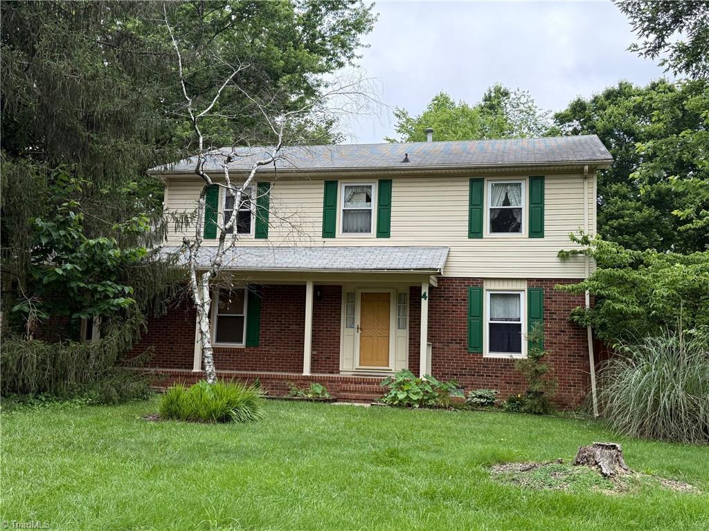 4 Frostbrook Ct, Greensboro, NC 27455 - traditional-style home featuring a front yard, brick siding, and covered porch