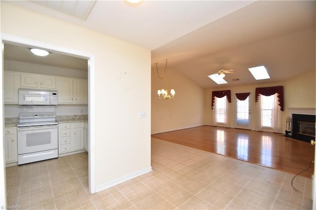 kitchen featuring white appliances, a fireplace with flush hearth, white cabinets, open floor plan, and light countertops