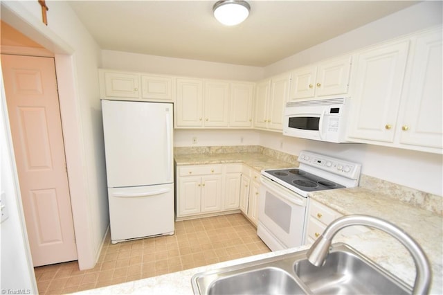 kitchen featuring light countertops, white appliances, a sink, and white cabinets