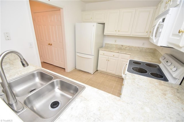 kitchen featuring white appliances, white cabinets, and a sink