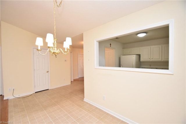 empty room with an inviting chandelier and baseboards