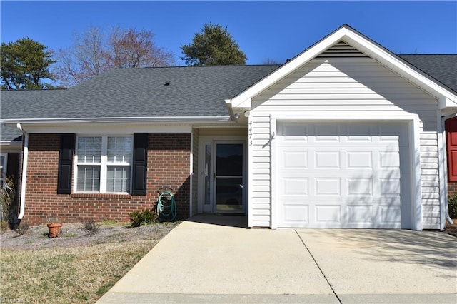 single story home with a garage, concrete driveway, brick siding, and roof with shingles