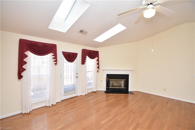 unfurnished living room featuring vaulted ceiling, a fireplace with flush hearth, wood finished floors, and visible vents