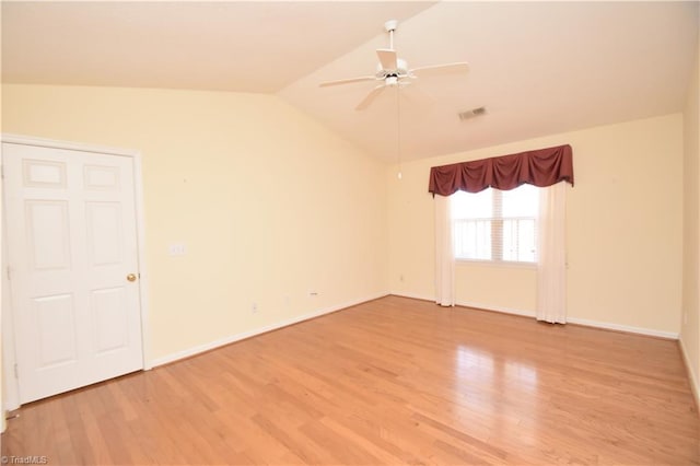 empty room featuring lofted ceiling, visible vents, light wood-style floors, ceiling fan, and baseboards