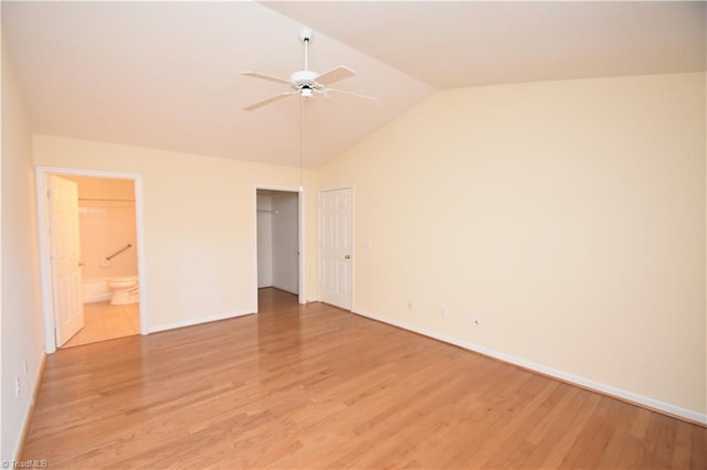 unfurnished bedroom with light wood finished floors, baseboards, connected bathroom, lofted ceiling, and ceiling fan