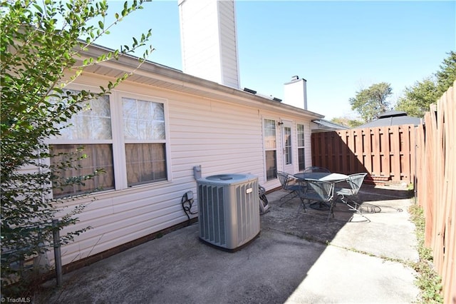 view of patio / terrace featuring central AC, outdoor dining area, and fence