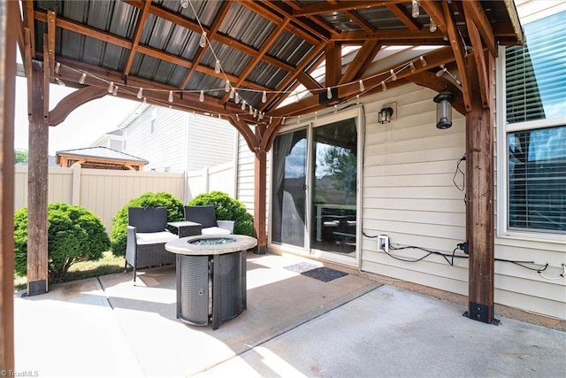 view of patio with fence, an outdoor fire pit, and a gazebo