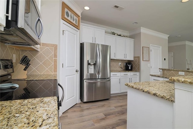 kitchen featuring light wood finished floors, stainless steel appliances, visible vents, crown molding, and tasteful backsplash