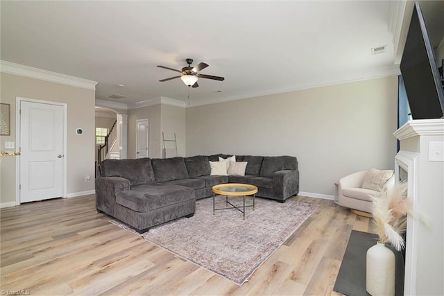 living area with visible vents, arched walkways, light wood-style floors, stairs, and ceiling fan