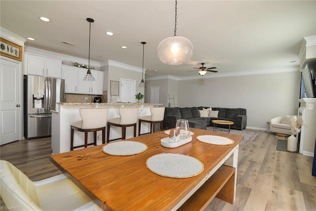 dining room featuring recessed lighting, crown molding, light wood-style flooring, and a ceiling fan
