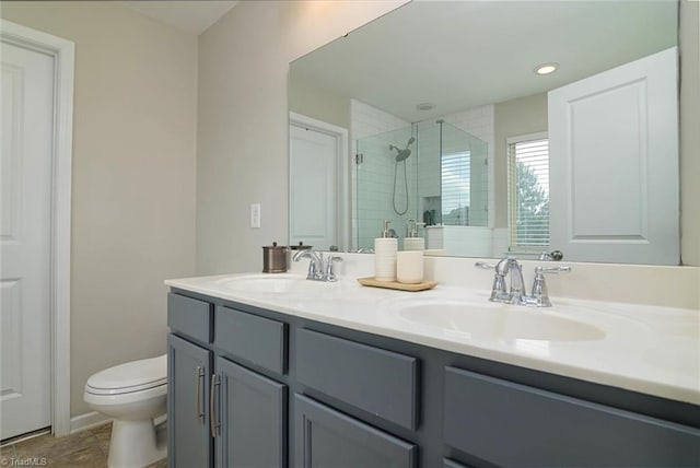 full bathroom with a shower stall, toilet, a sink, and double vanity