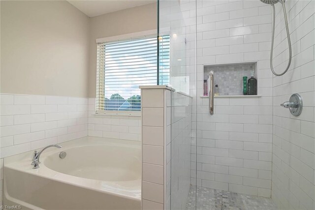 bathroom with a shower stall and a bath