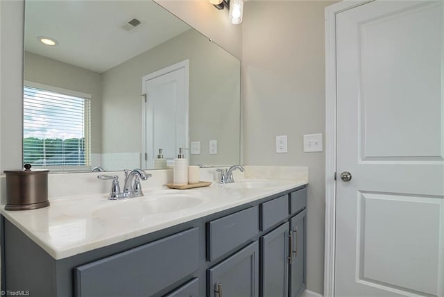 bathroom featuring visible vents, a sink, recessed lighting, and double vanity