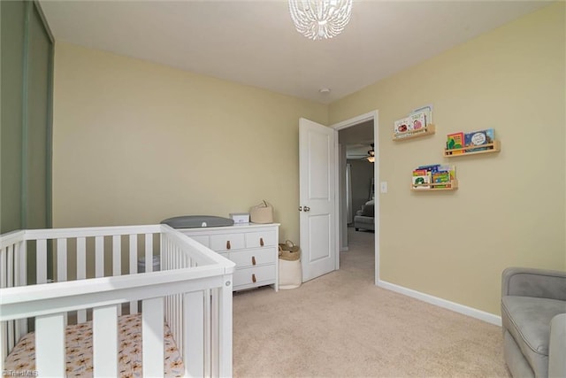 bedroom featuring light carpet, baseboards, and a nursery area