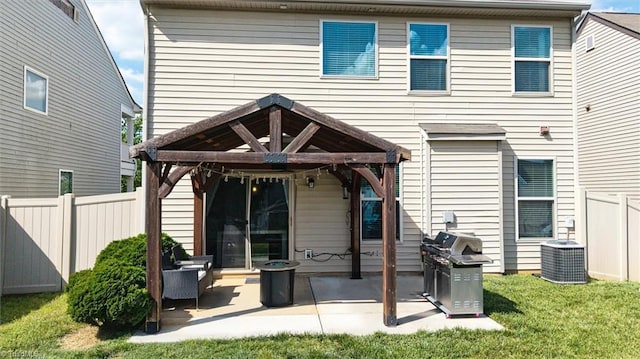 back of property featuring a gazebo, a patio area, central air condition unit, fence, and a yard