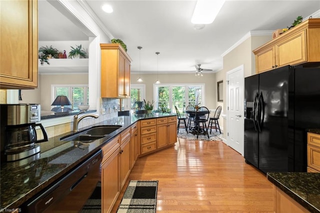 kitchen with sink, black appliances, pendant lighting, and plenty of natural light