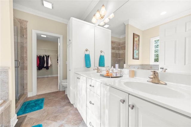 bathroom with vanity, toilet, crown molding, and a shower with door