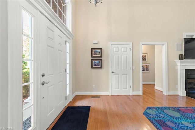 entryway featuring a towering ceiling and wood-type flooring