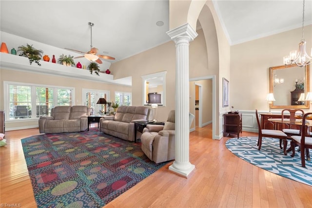 living room featuring light hardwood / wood-style floors, decorative columns, and ceiling fan with notable chandelier