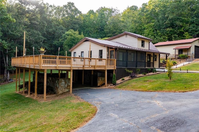 back of property featuring a deck and a lawn