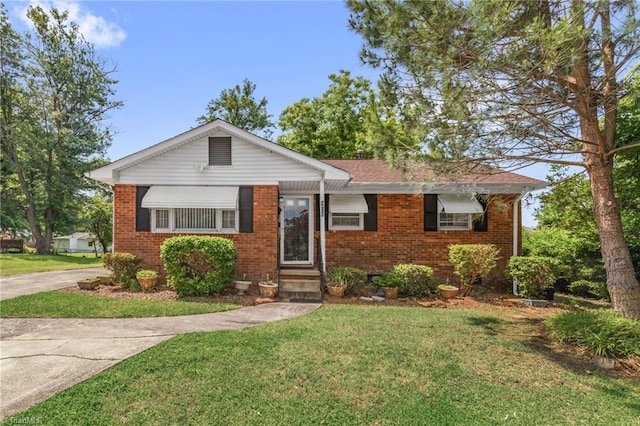 904 Ashe St, Greensboro, NC 27406 - view of front facade featuring a front yard, brick siding, and entry steps
