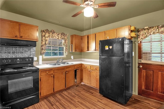 904 Ashe St, Greensboro, NC 27406 - kitchen featuring black appliances, exhaust hood, wood finished floors, light countertops, and a ceiling fan