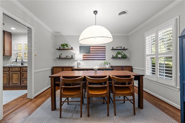 1603 Ilchester Ct, Greensboro, NC 27408 - dining room featuring wood finished floors, healthy amount of natural light, and crown molding