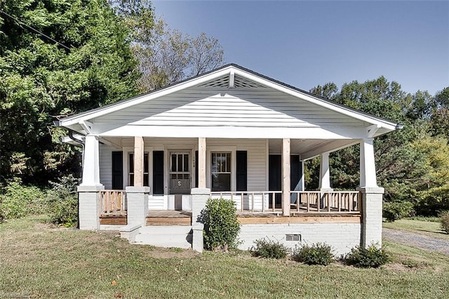 view of front facade with crawl space, covered porch, and a front lawn